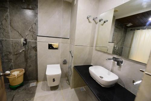 ein Bad mit einem WC, einem Waschbecken und einer Dusche in der Unterkunft Puri Beach Resort in Puri