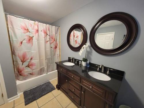 a bathroom with two sinks and a mirror at Cottage in Downtown Houma in Houma