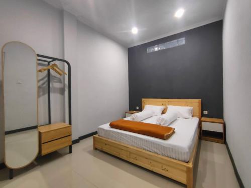 a bedroom with a bed and a mirror at Kartini Stay in Lampung