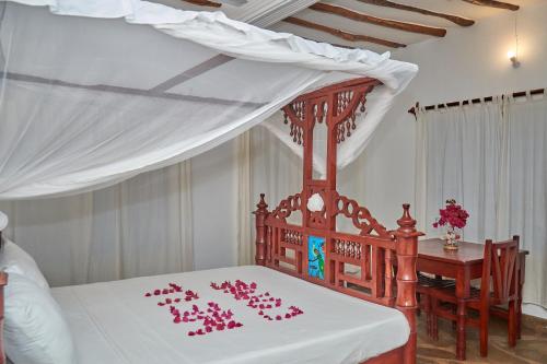 a bedroom with a bed with pink decorations on it at Beach Way Villa in Malindi