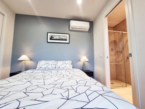 a bedroom with a large bed and a shower at Rosie Townhouse - Modern home in Sunshine in Albion