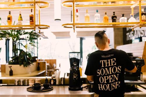 a man standing at a counter in a coffee shop at The Somos Bold Hotel in Medellín