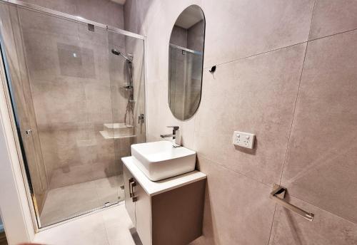 a bathroom with a sink and a shower at Rosie Townhouse - Modern home in Sunshine in Albion