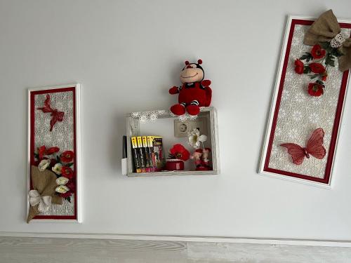 a white wall with a shelf with a stuffed animal on it at Flower Breeze in Chebanka