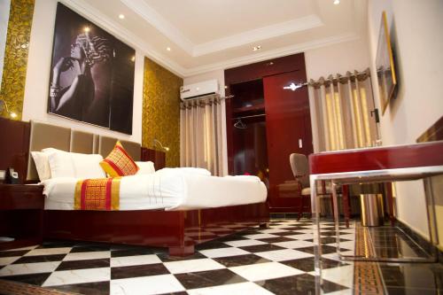 een slaapkamer met een bed en een geruite vloer bij Capitole Hotel in Abidjan
