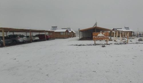 um grupo de edifícios com neve no chão em Paramitas - cabañas y hostel de montaña em Uspallata