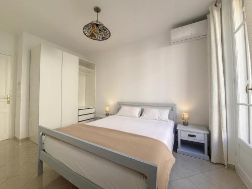 une chambre blanche avec un lit et une fenêtre dans l'établissement Nestor&Jeeves - JACARANDA - Carre d Or, Proche mer, à Nice