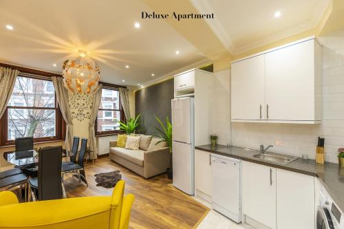 a kitchen and living room with a couch and a table at Stylish Apartment Kensington in London