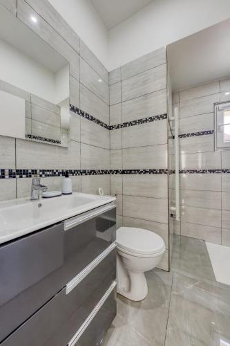 une salle de bain blanche avec des toilettes et un lavabo dans l'établissement Joli Appartement de vacances, à Écouen