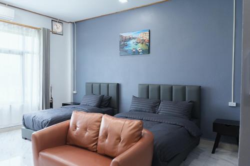 a bedroom with two beds and a couch at Tulip Hotel in Louang Namtha