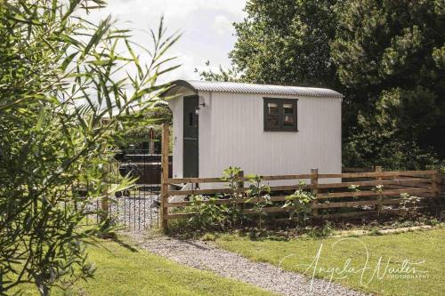 a small white shed with a wooden fence at Robins Rest in the North York Moors in Rosedale Abbey