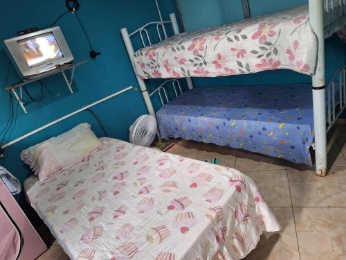 a bedroom with two bunk beds and a tv at Mel Pousada in Macaé