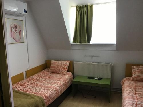 um pequeno quarto com duas camas e uma mesa em Villa Siret em Galaţi