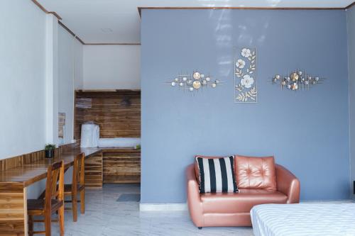 Zimmer mit einem Bett, einem Stuhl und einem Tisch in der Unterkunft Tulip Hotel in Louang Namtha