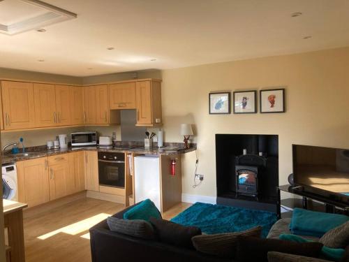 uma sala de estar com um sofá e uma cozinha com um fogão em The Chalet In The New Forest - 5 km from Peppa Pig! em Southampton
