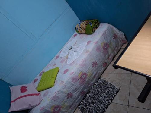 a small bed in a room with a table at Mel Pousada in Macaé