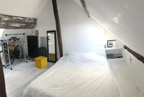 - une chambre avec un lit blanc et un tabouret jaune dans l'établissement Duplex apartment with amazing views, à Paris