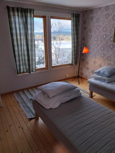 a bedroom with a bed and a large window at Gula huset in Rottneros