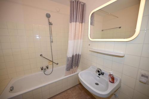 uma casa de banho com um lavatório, um chuveiro e uma banheira em Haus 1 top 38 em Kaprun