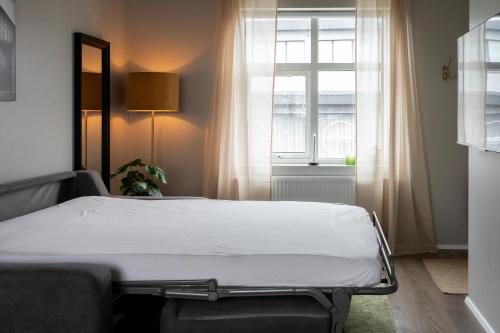 łóżko w pokoju z oknem w obiekcie Ray of Sunshine Hafnargata w Keflavíku
