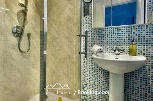 ein Bad mit einem Waschbecken und einer Dusche mit einem Spiegel in der Unterkunft Two Bed Apartment At Primal Estates Short Lets in Brighton in Brighton & Hove