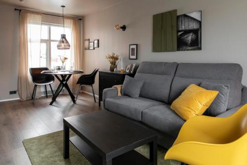 a living room with a gray couch and a table at Ray of Sunshine Hafnargata in Keflavík