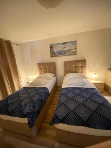 two beds sitting next to each other in a room at Apartment Bilic in Split
