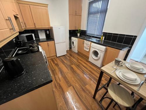 a kitchen with wooden floors and a counter top at Super Value Three Bedroom House in Hull