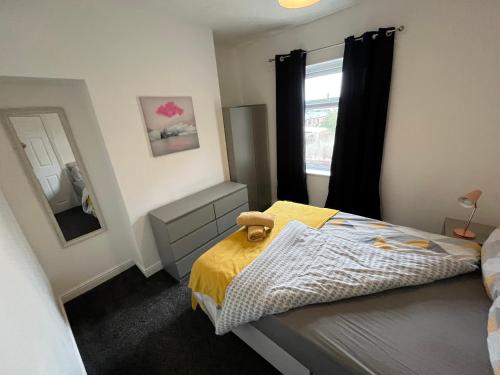 Dormitorio pequeño con cama y espejo en Super Value Three Bedroom House en Hull