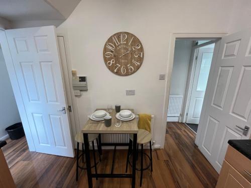 a kitchen with a table and a clock on the wall at Super Value Three Bedroom House in Hull