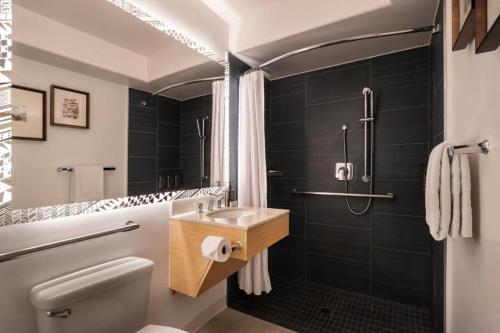 a bathroom with a toilet and a sink and a shower at Sheraton Kauai Coconut Beach Resort in Kapaa