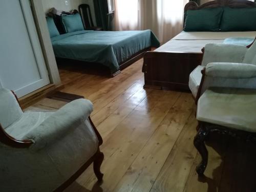 a room with two beds and a couch and a chair at Golden Gate in Akhaltsikhe