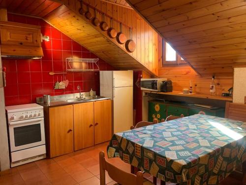 a kitchen with a table and a refrigerator and a stove at Sopra la Scaletta in Lavarone