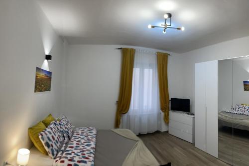 um quarto com uma cama, uma televisão e uma janela em Savonarola residence em Alessandria