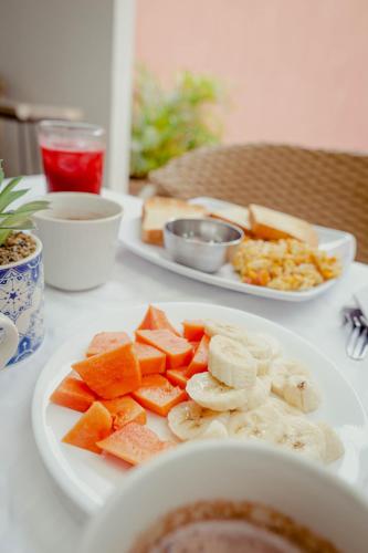Dos platos de comida en una mesa con fruta. en Hotel Casamart Rodadero, en Santa Marta