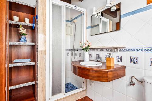 uma casa de banho com um lavatório de madeira e um espelho em Villa Juana Blanes em Cala en Blanes