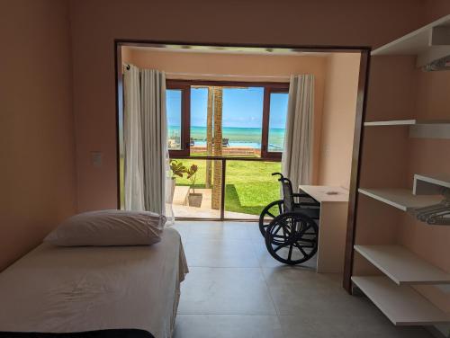 a bedroom with a bed and a view of the ocean at Slater's House - Casa de praia em frente ao mar in Paripueira