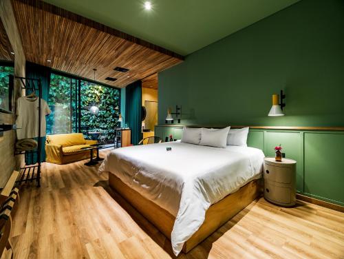 una camera con un grande letto e una parete verde di The Somos Bold Hotel a Medellín