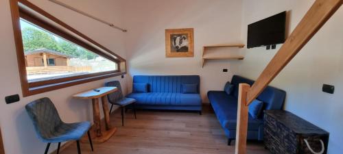 sala de estar con sofá azul y ventana en Campaegli resort, en Campaegli