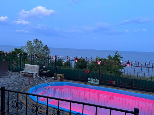 a swimming pool with a view of the ocean at Flower Breeze in Chebanka
