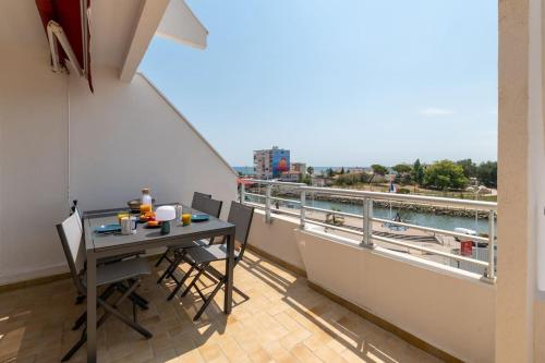 d'un balcon avec une table et une vue sur l'eau. dans l'établissement La Brise Marine * Carnon * Plage à 5 min * Proche Montpellier, à Mauguio