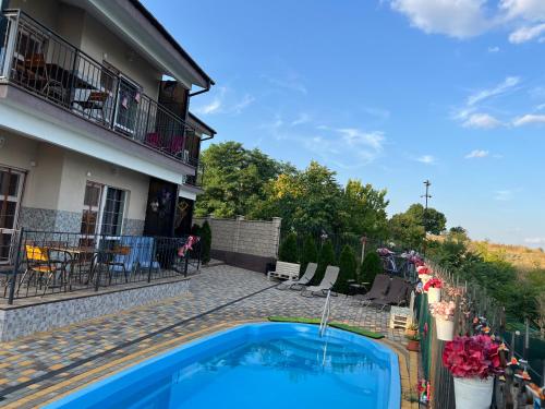a house with a swimming pool next to a building at Flower Breeze in Chebanka