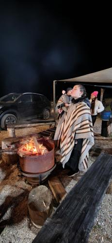a woman sitting on a bench next to a car at Maravillosas Vistas Boyeruca Lodge in Vichuquén
