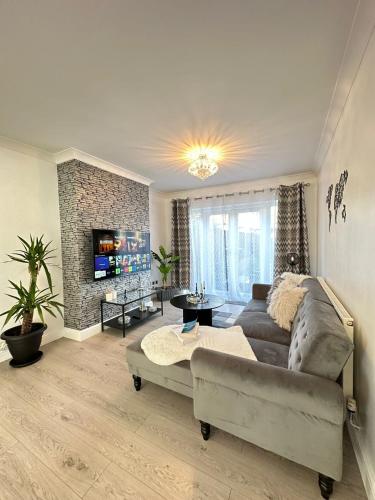 een woonkamer met een bank en een open haard bij Luxurious family home in West Midlands in Northfield