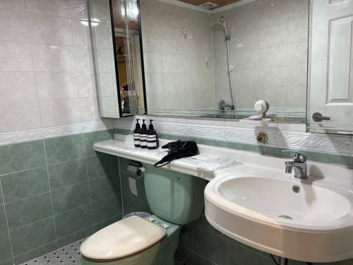 a bathroom with a sink and a toilet and a mirror at Haru Airport Stay Gimpo in Seoul