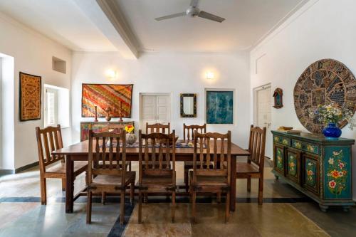 a dining room with a wooden table and chairs at The People Hostel in Udaipur