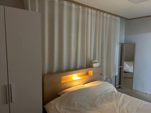 una camera da letto con un letto con una luce sopra di esso di Haru Airport Stay Gimpo a Seul