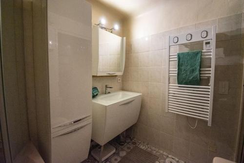 une salle de bain blanche avec un lavabo et un miroir dans l'établissement Charmant T3 centre historique, parking, à Aix-en-Provence