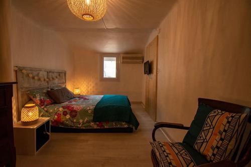 une chambre avec un lit, une chaise et une lampe dans l'établissement Charmant T3 centre historique, parking, à Aix-en-Provence