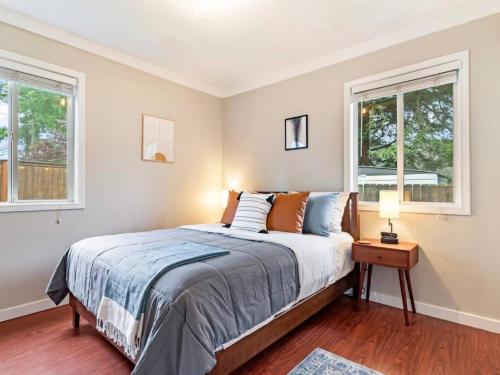 - une chambre avec un lit et 2 fenêtres dans l'établissement Cheerful 2-bedroom Home Near UP and St. Johns, à Portland